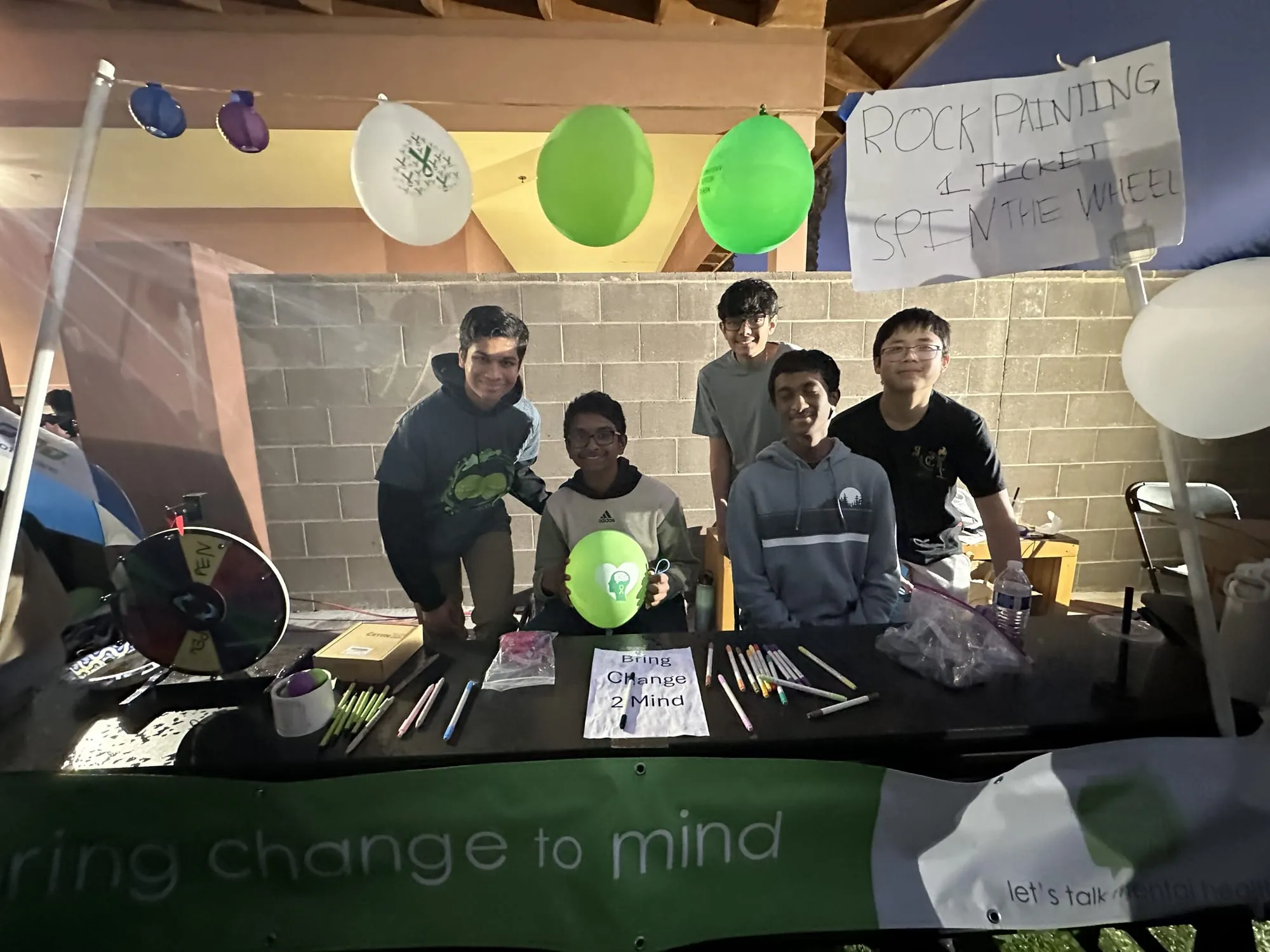 Students running a rock painting and spin the wheel booth